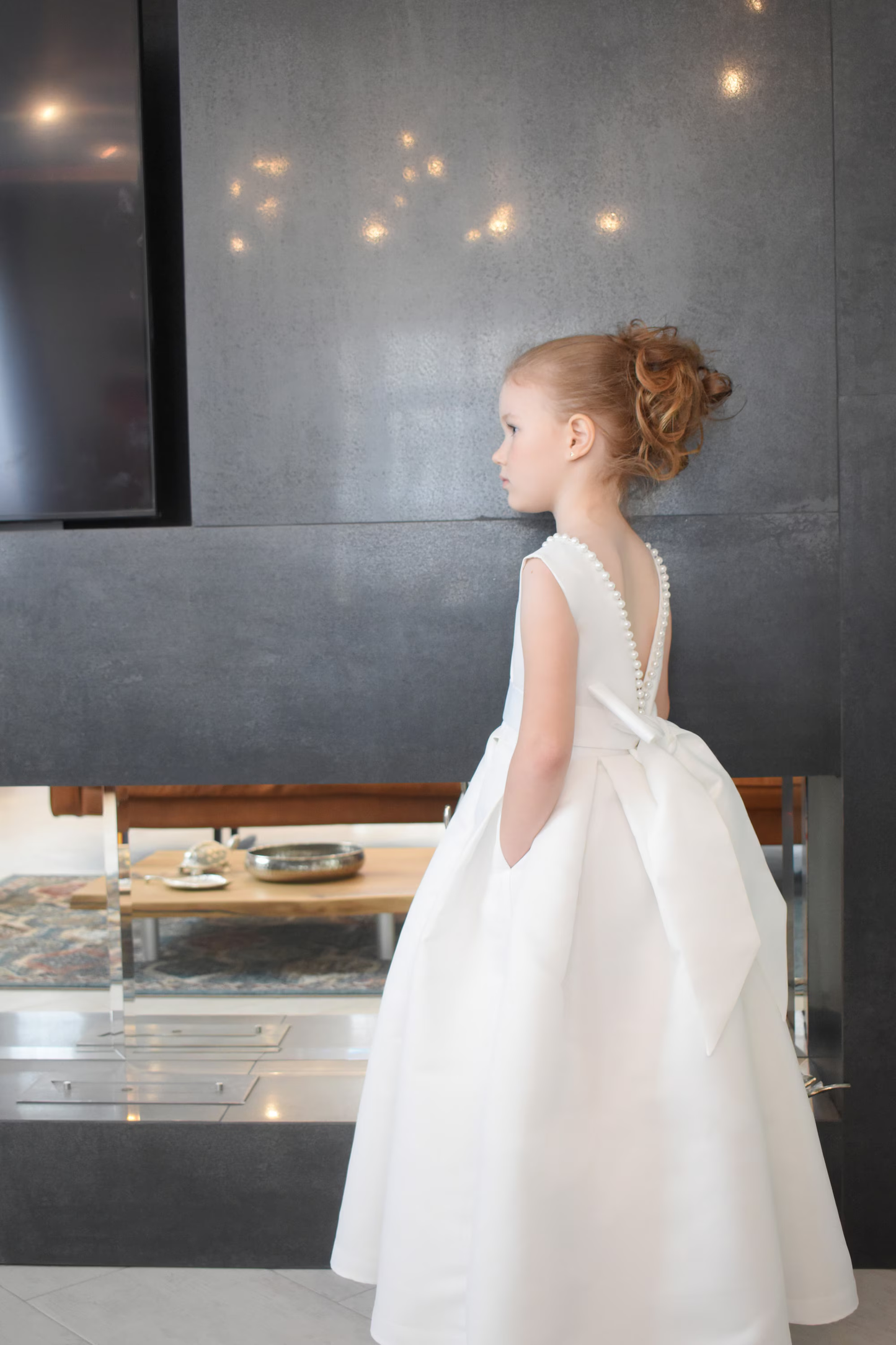 Ivory satin flower girl dress with pearl-trimmed V-back, satin bow and floor-length ball gown skirt