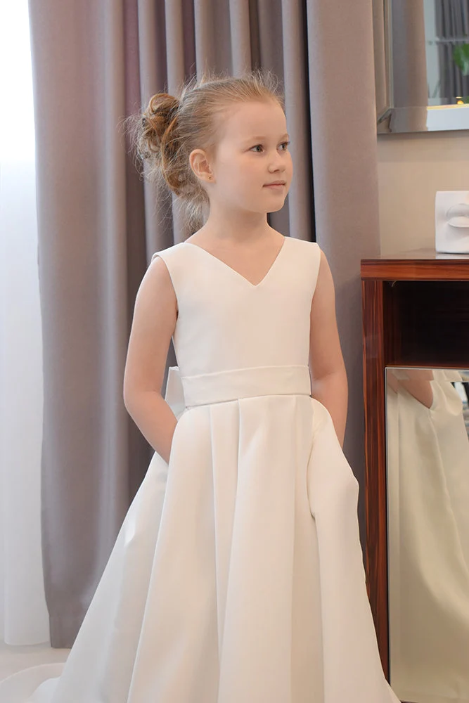 Ivory satin flower girl dress with V-neckline, wide satin waistband and box-pleated ball gown skirt, side pockets visible